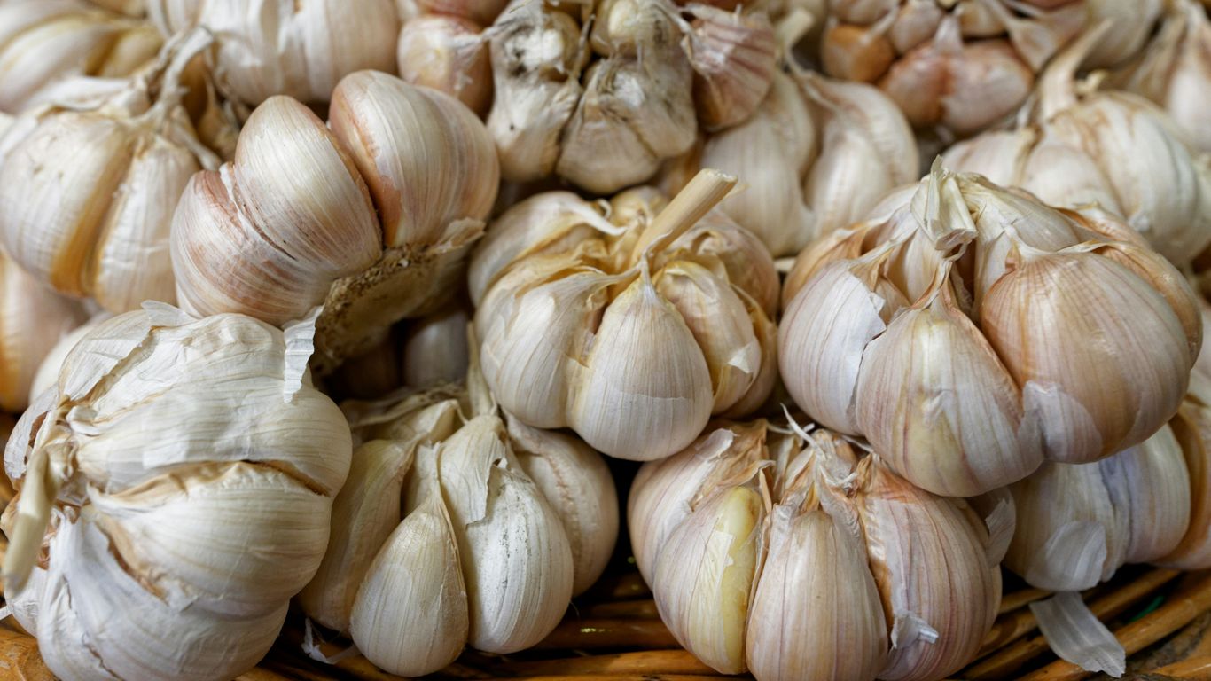 a basket filled with lots of garlic on top of a table