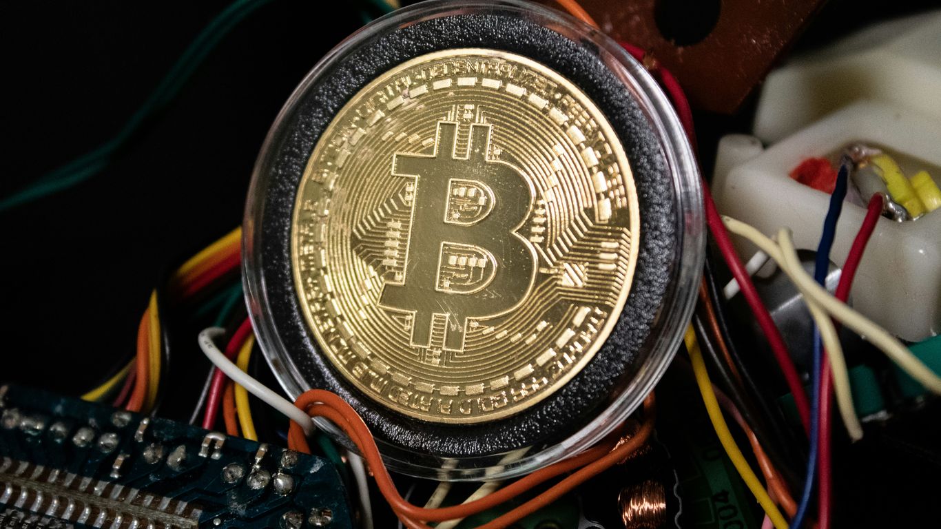 Bitcoin token surrounded by colorful electronic circuit wires.