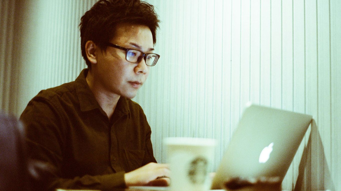 a man sitting at a table using a laptop computer