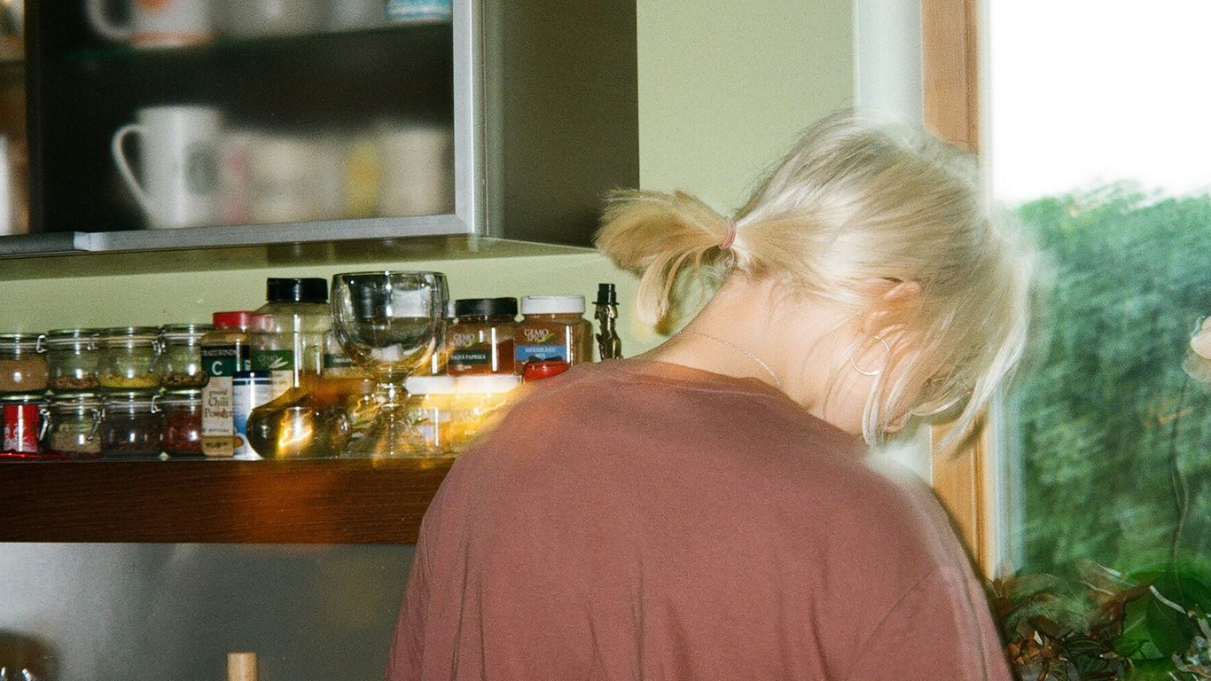 a woman standing in a kitchen next to a window