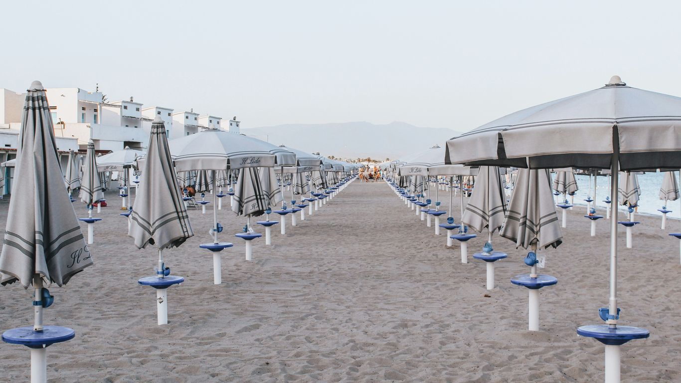 white and blue beach umbrellas on beach during daytime