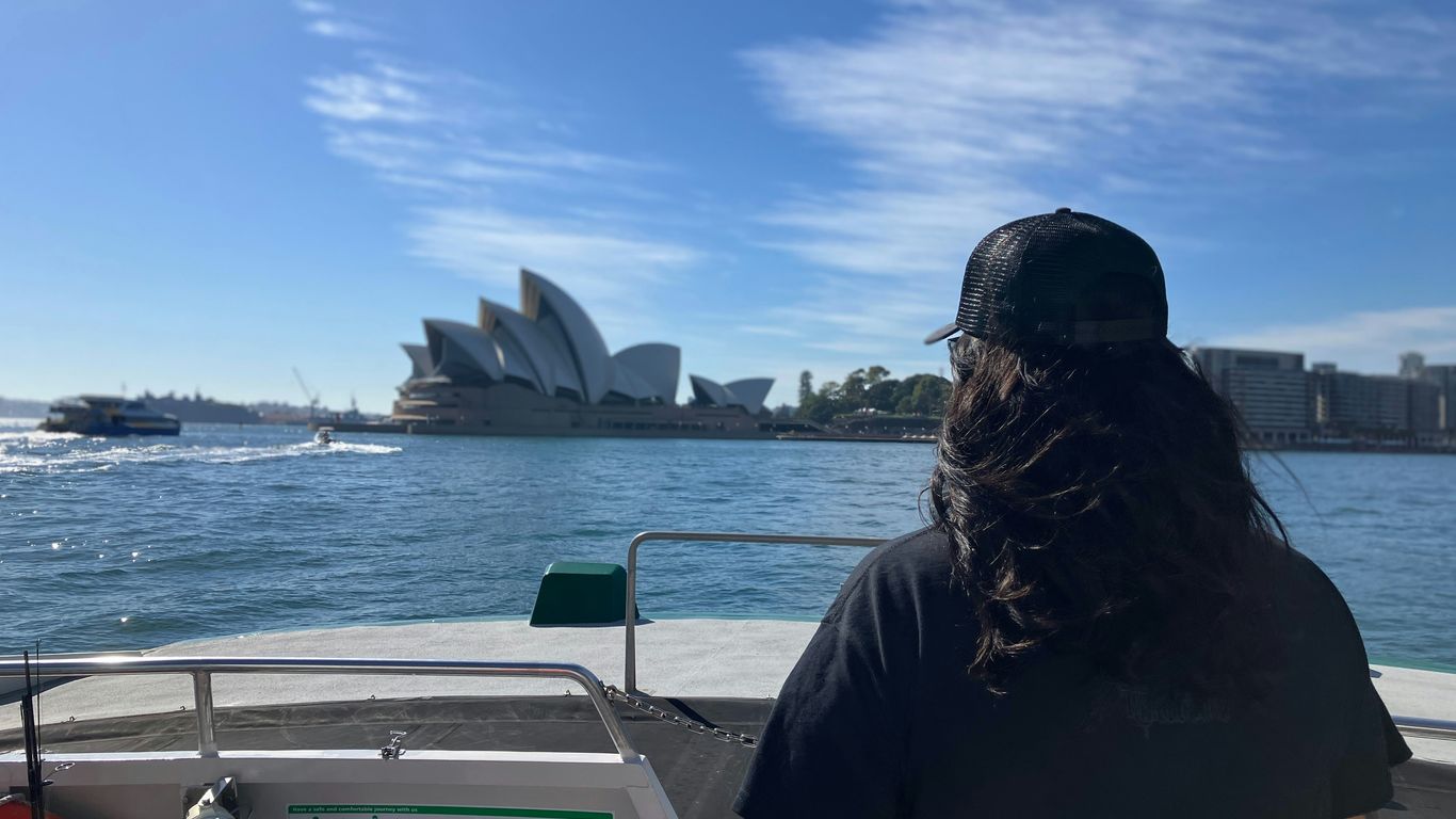 a woman sitting on a boat looking out at the water
