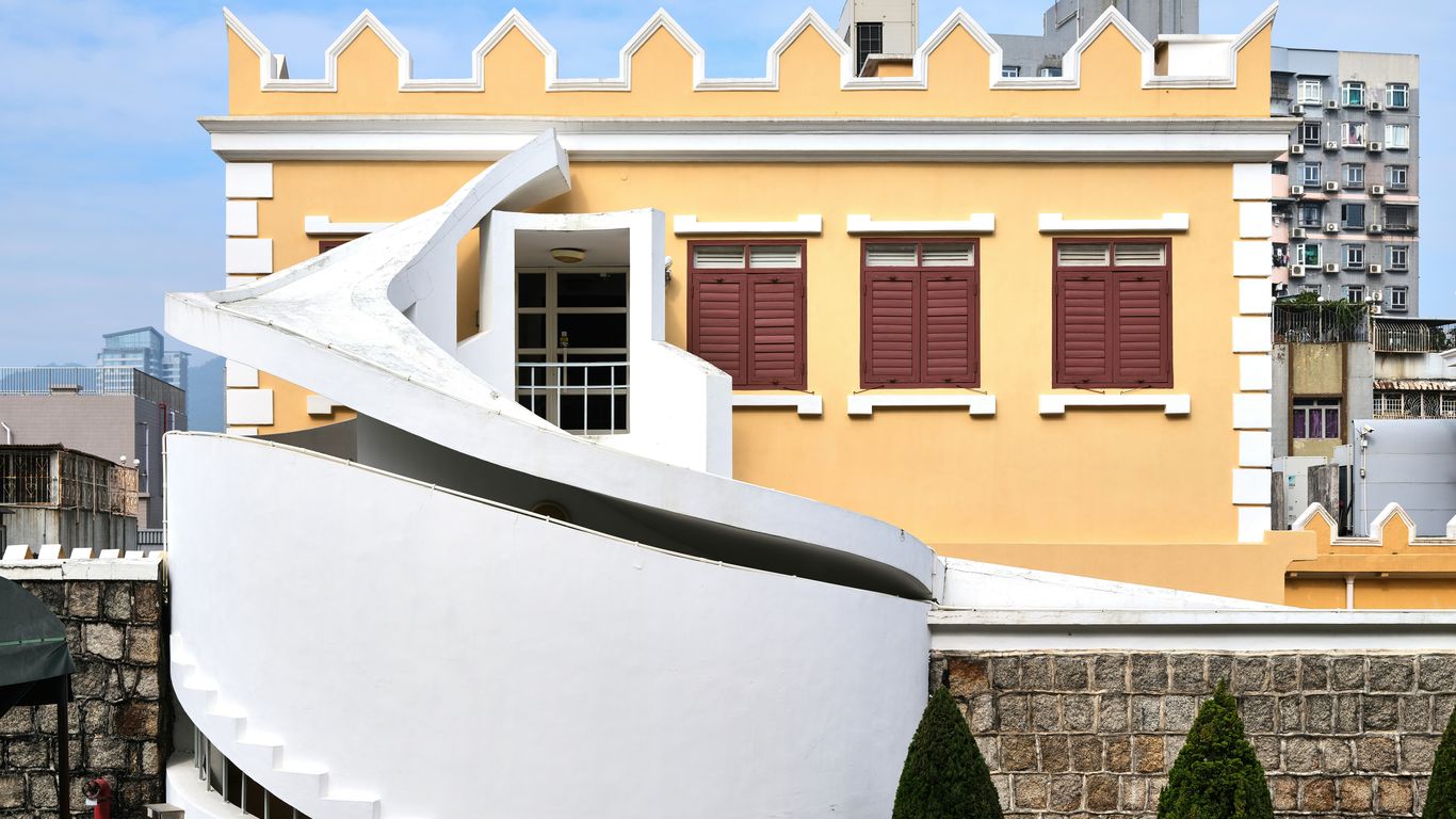 A large white boat sitting in front of a building