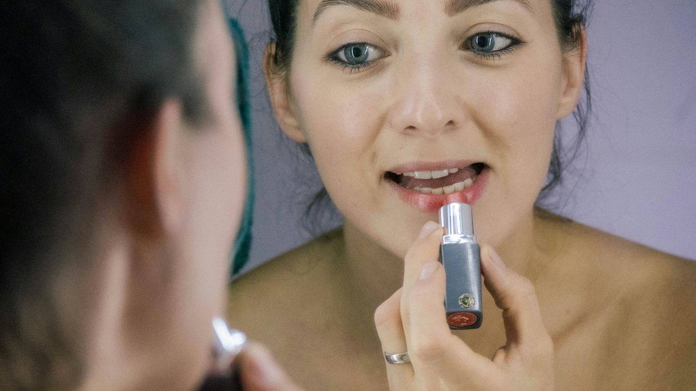 a woman brushing her teeth in front of a mirror