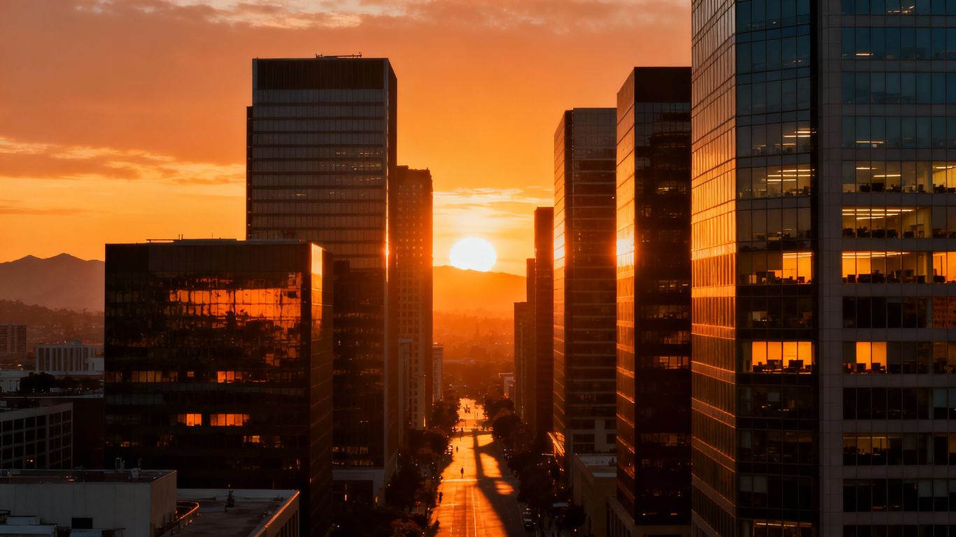 Phoenix skyline at sunset with glowing office buildings.