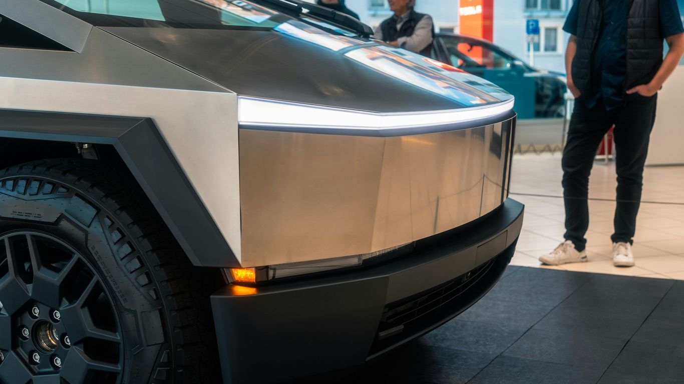 A man standing next to a silver car