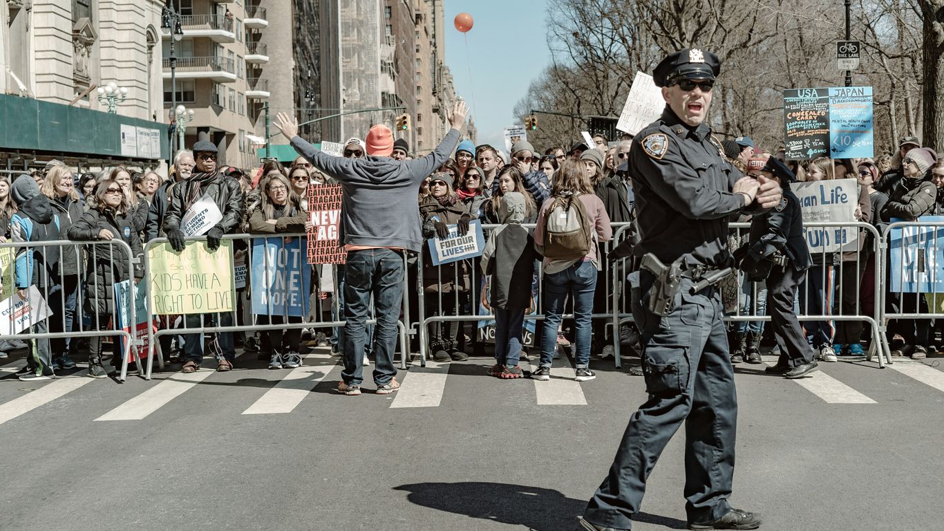 police man standing on road near people watching