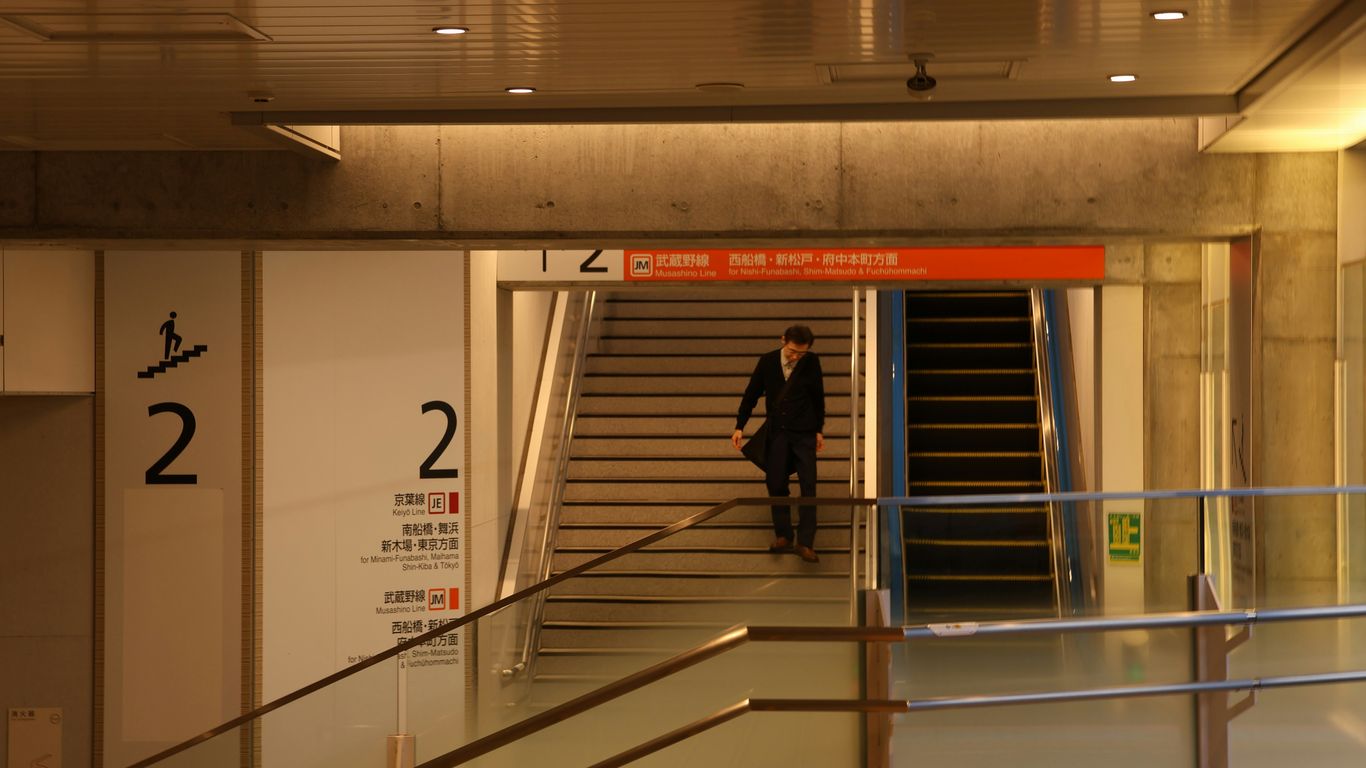 Man walks down stairs in modern building interior.