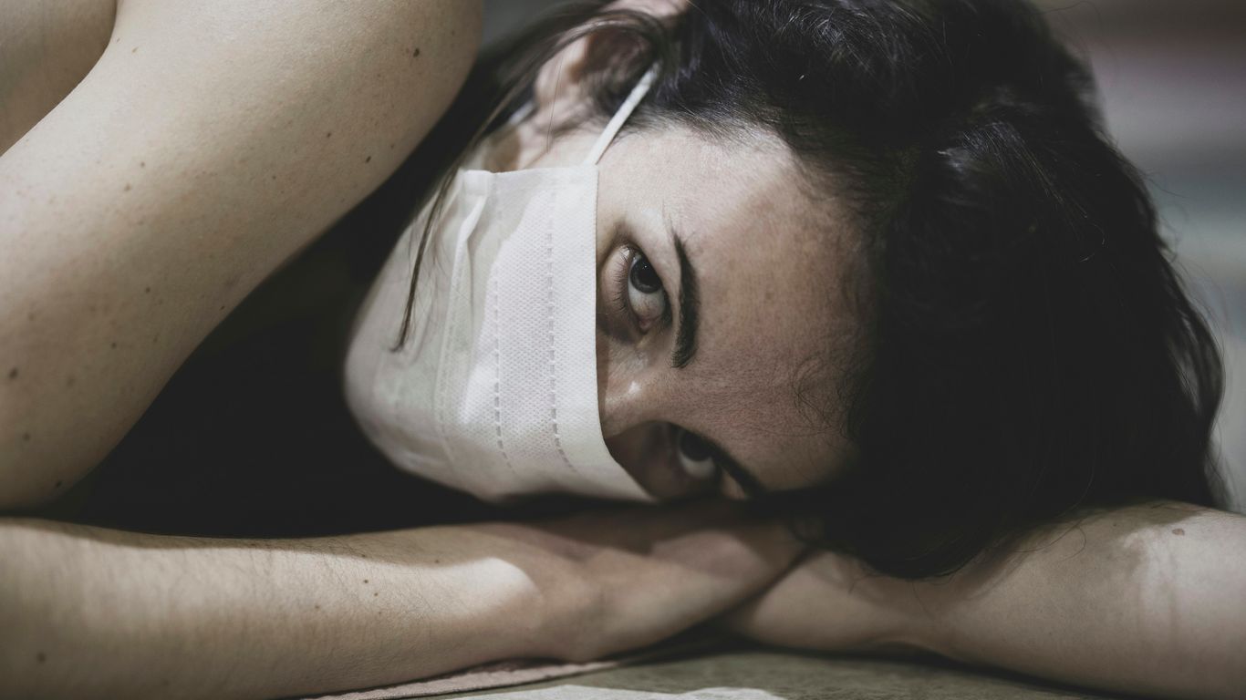 woman lying on white textile