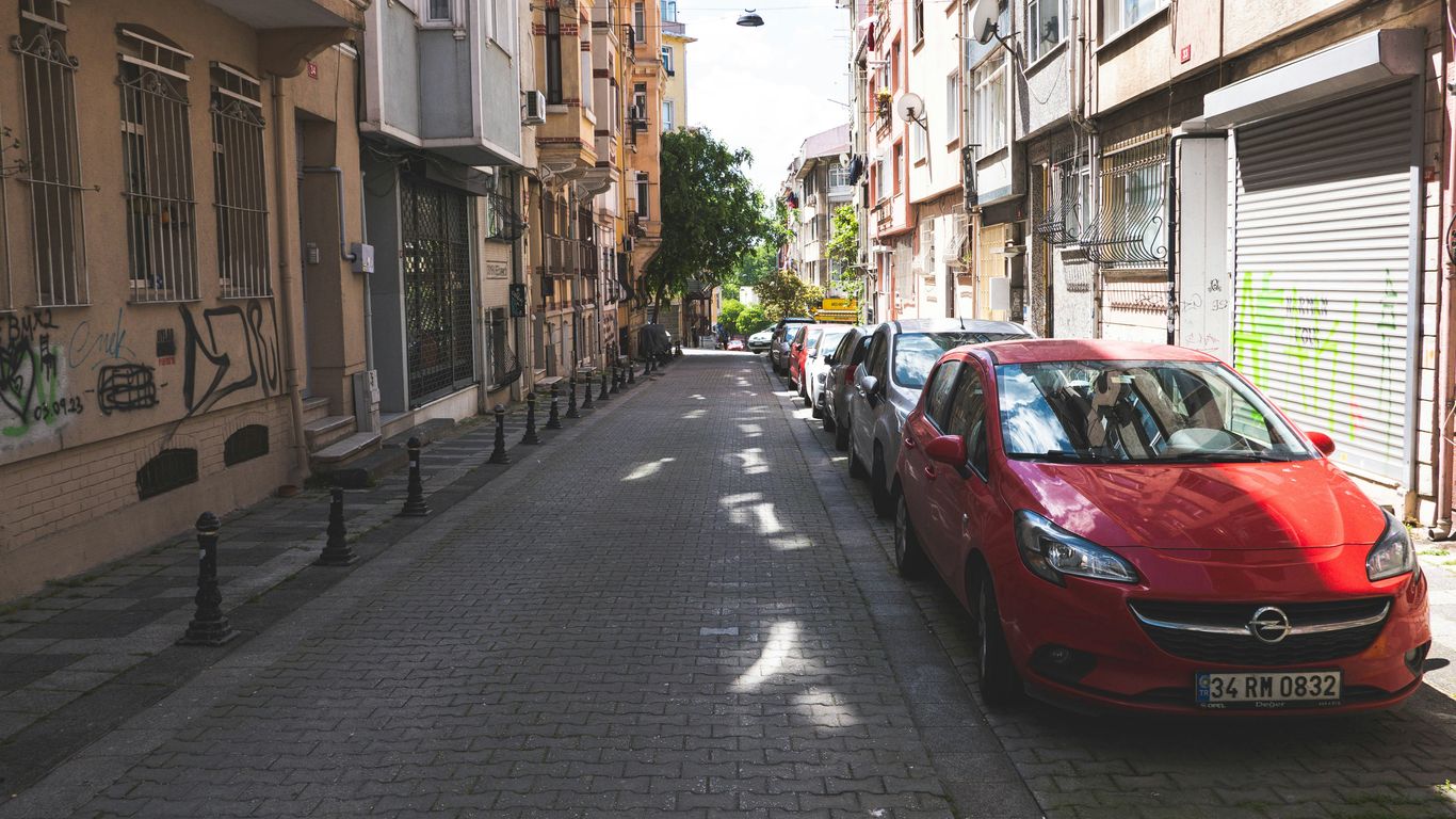 A red car parked on the side of a street