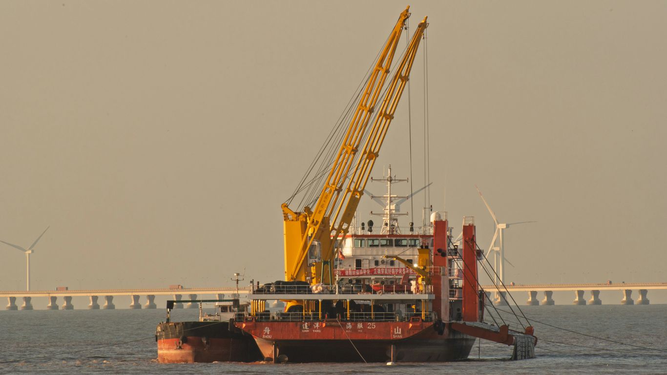 A large dredging vessel with cranes on the water.