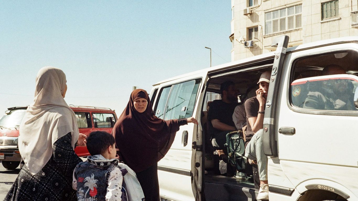 A group of people standing next to a white van
