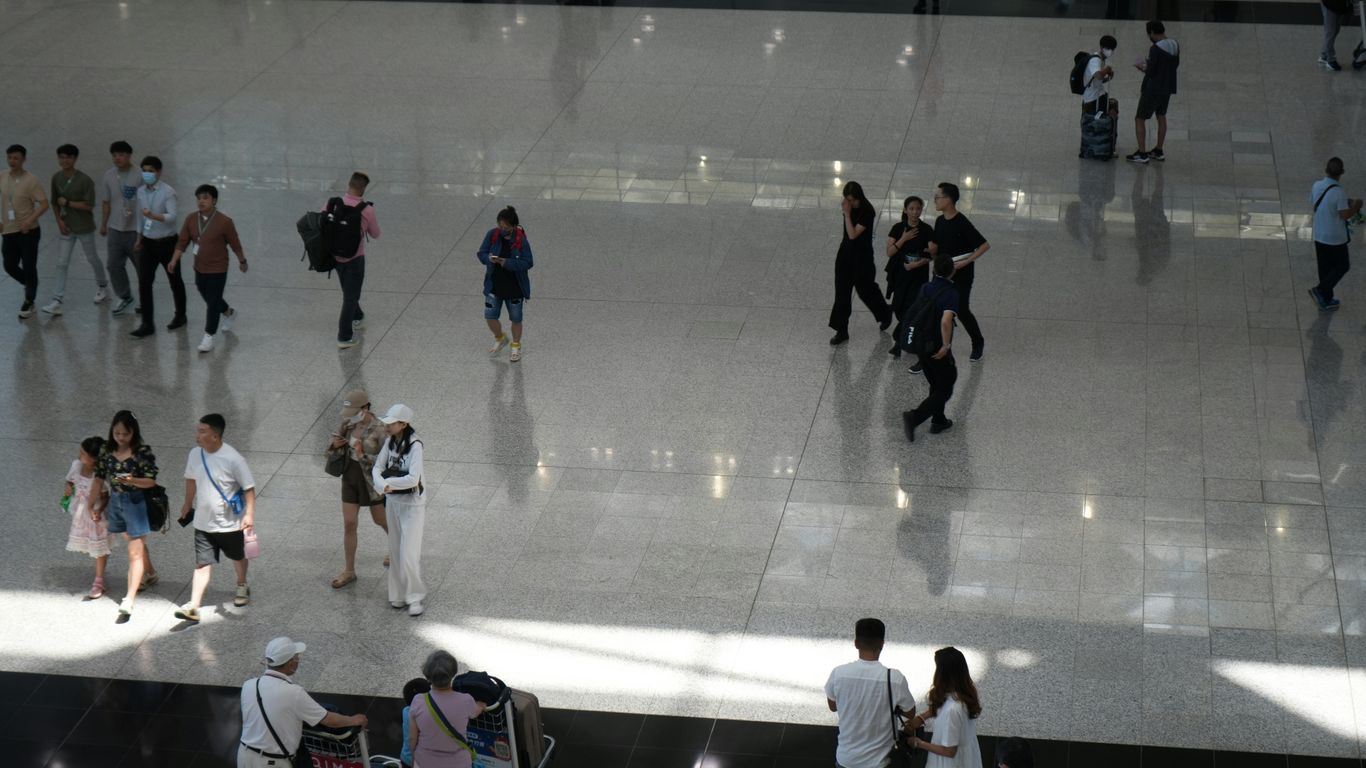 a group of people walking around a building