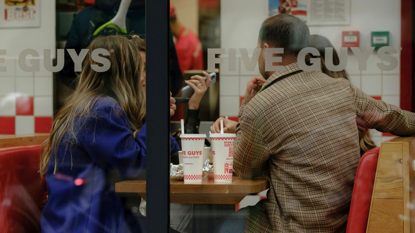 a man and woman sitting at a table with cups on it