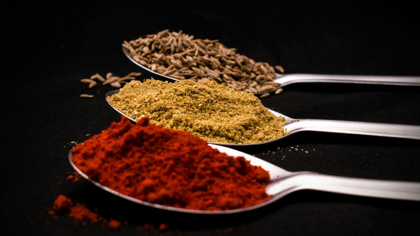 three spoons filled with different types of spices