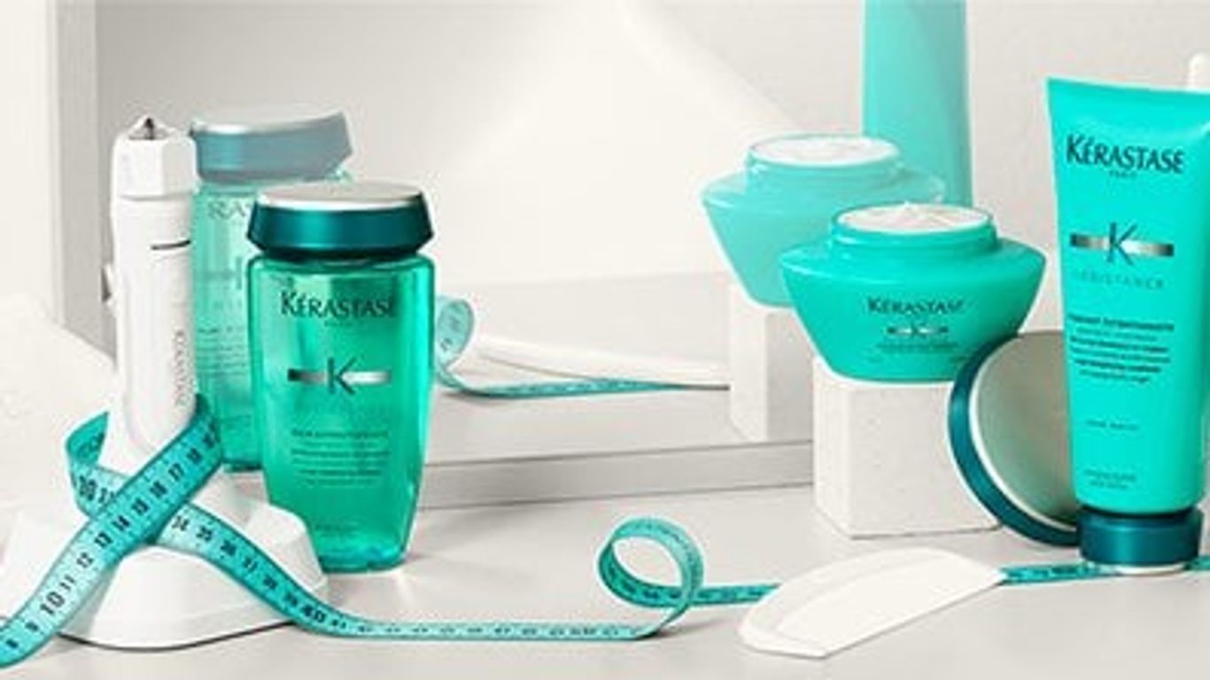 Assorted Kérastase haircare products with a teal measuring tape.