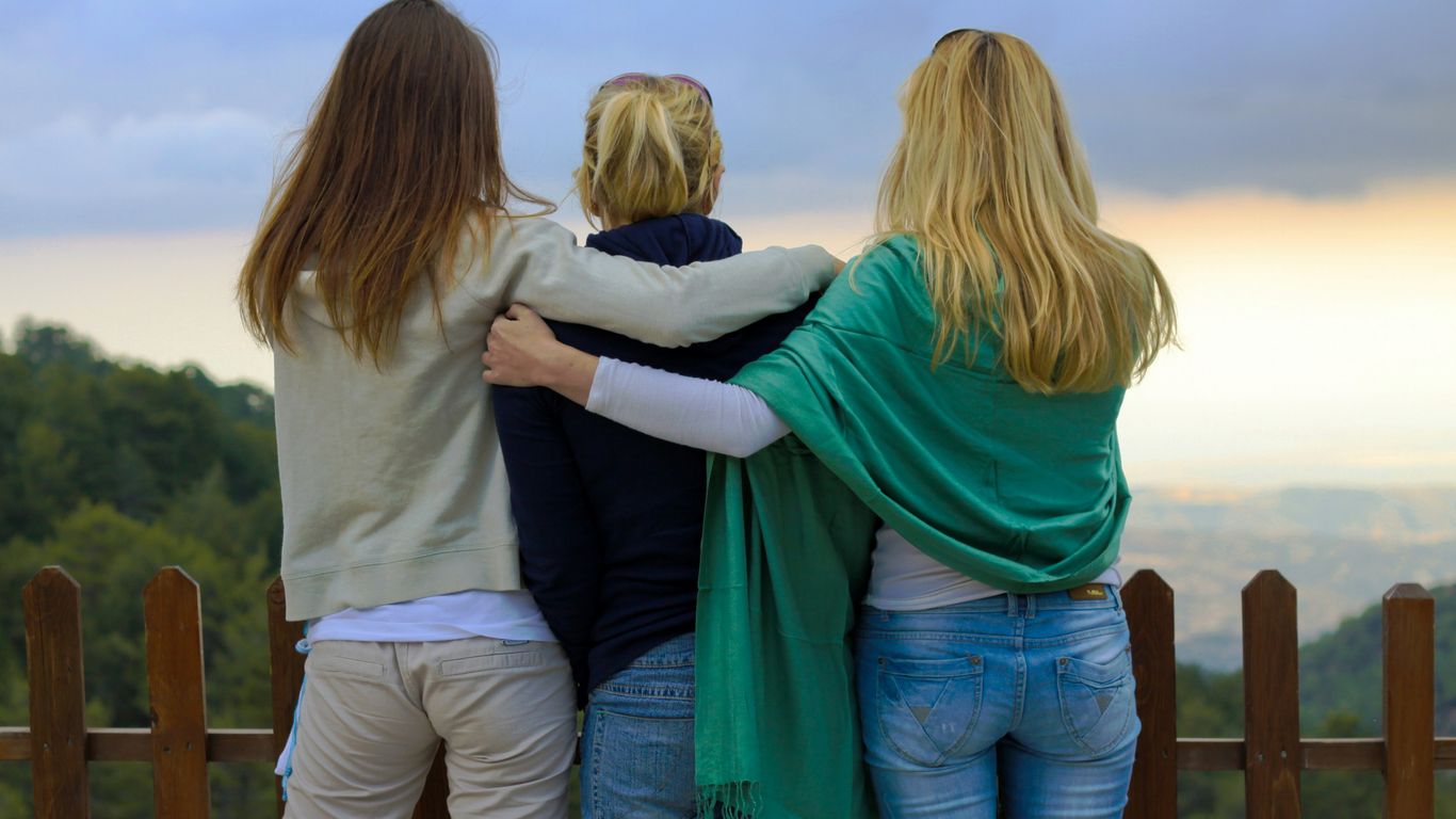 a group of three women standing next to each other