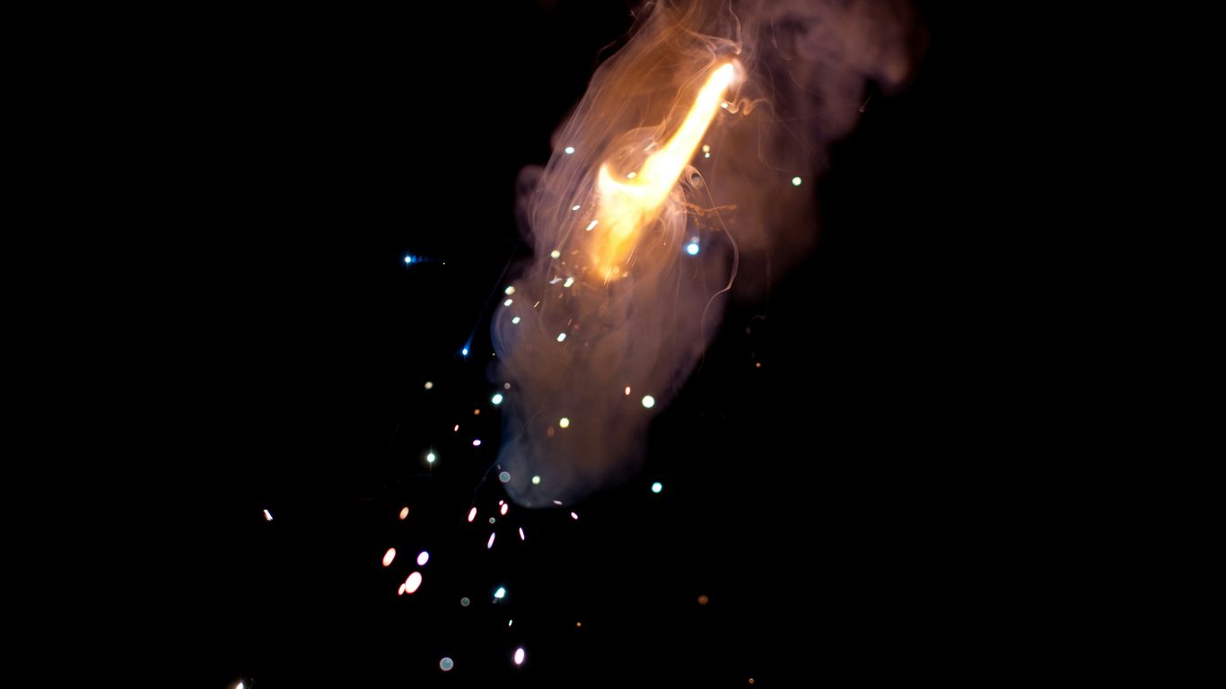 a black background with a lit object in the middle of it