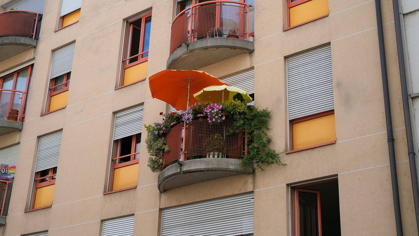 a building with a balcony and a potted plant on the balcony