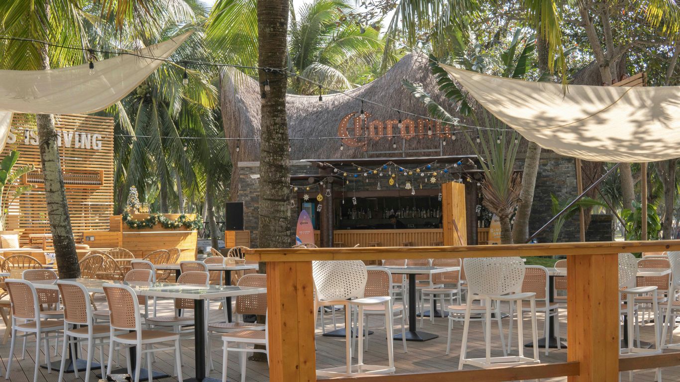 a wooden deck with tables and chairs under a canopy
