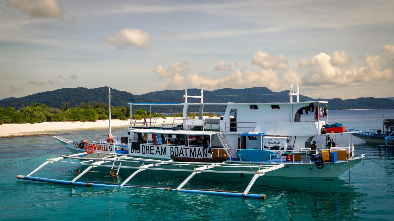 A white catamaran boat floats on turquoise water.