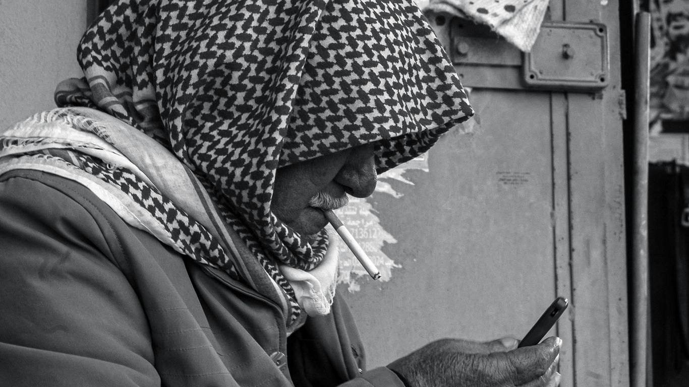 a woman in a headscarf looking at her cell phone