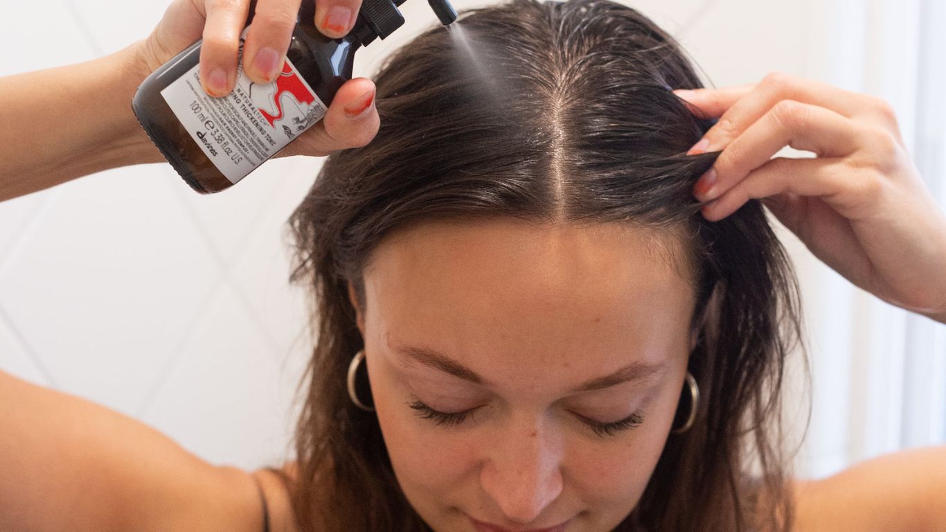 Applying hair treatment product, self-care routine, indoors, close-up view.