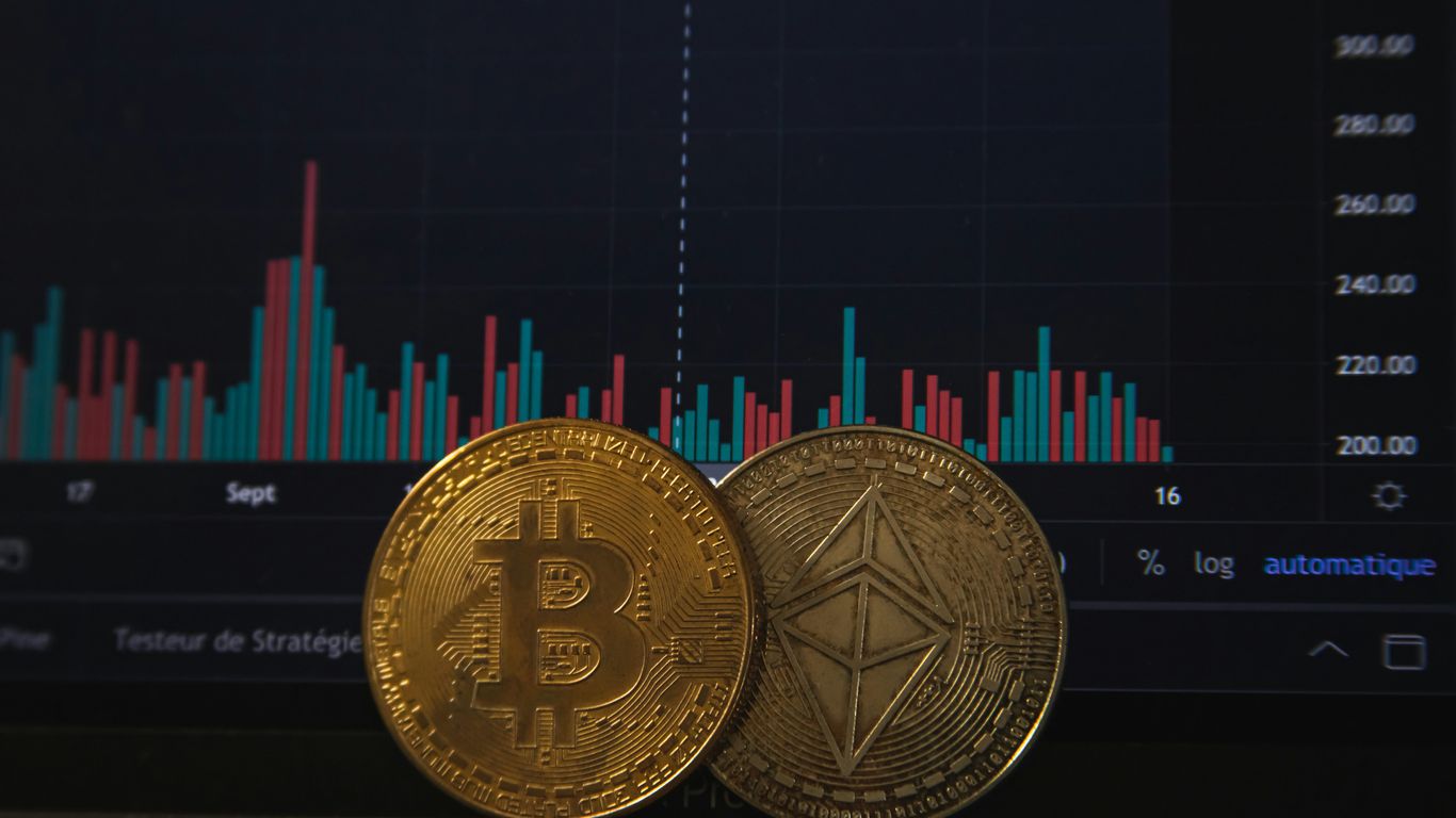 Two cryptocurrency coins in front of a financial graph.