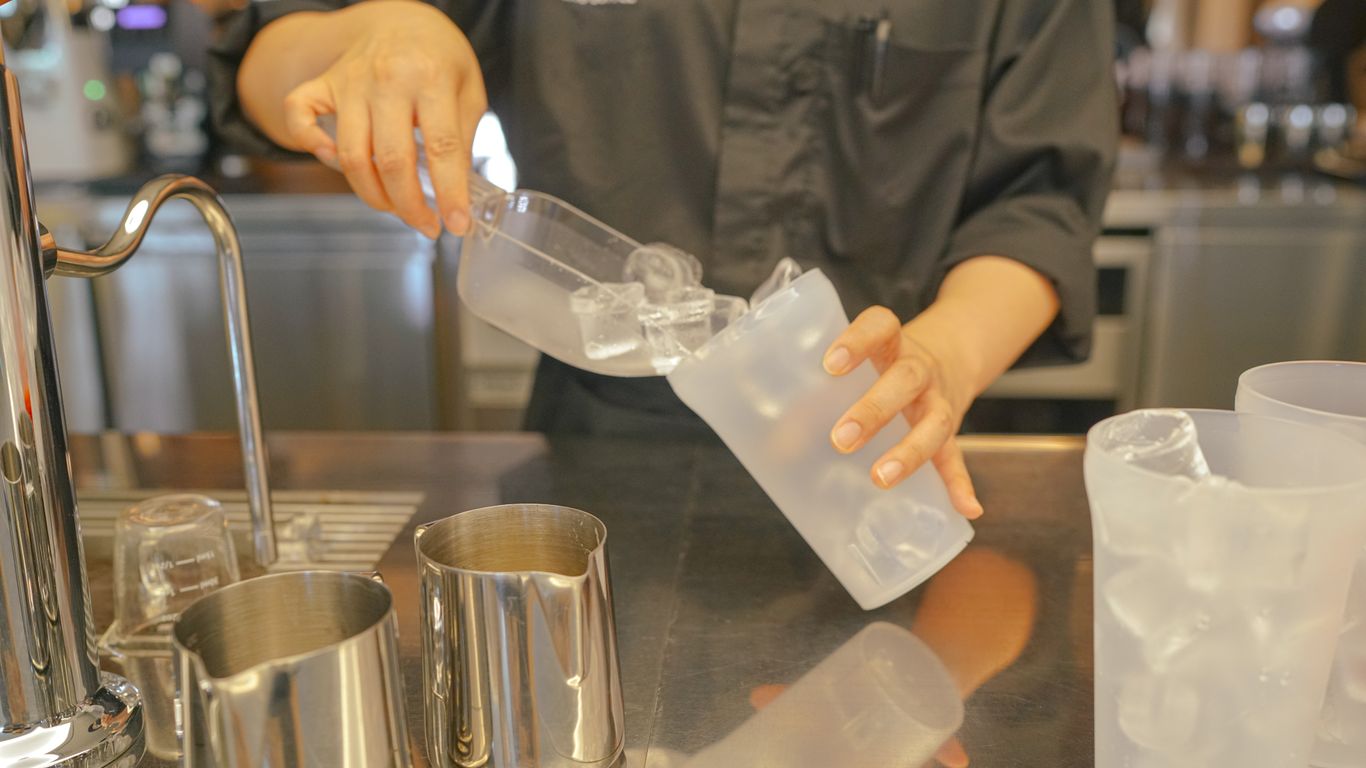 a person pouring a drink into a glass