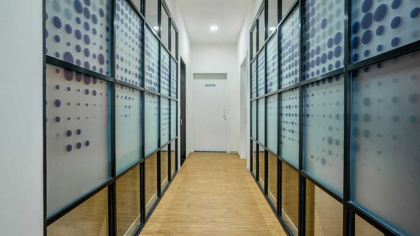 a long hallway with glass walls and a wooden floor