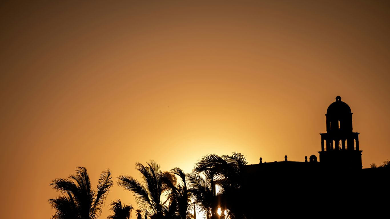 a silhouette of a building and some trees