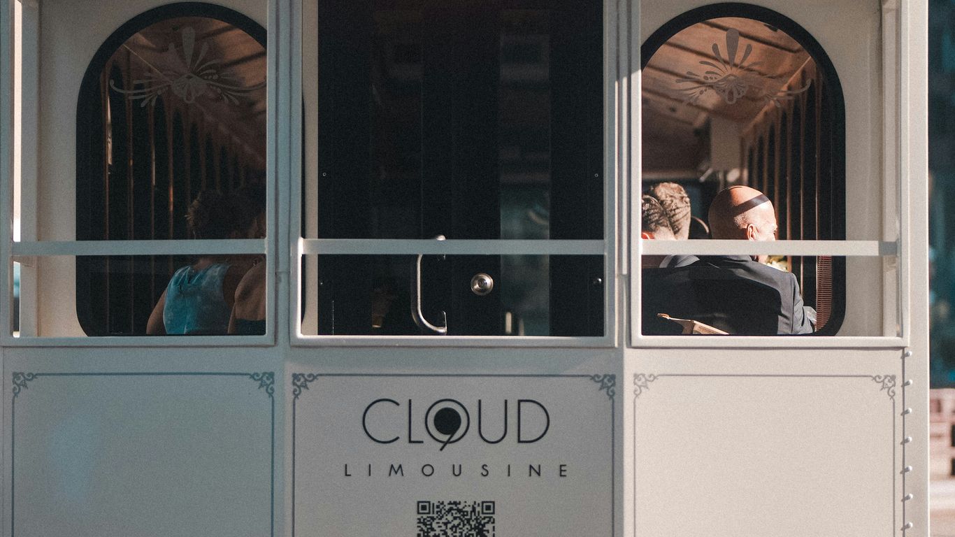 People ride on a trolley car in the city.