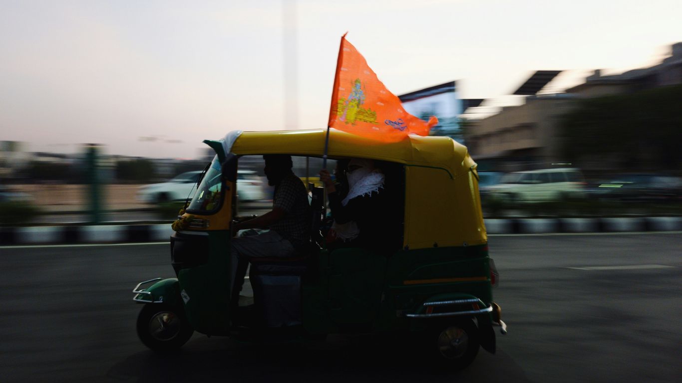 a man driving a small green and yellow vehicle