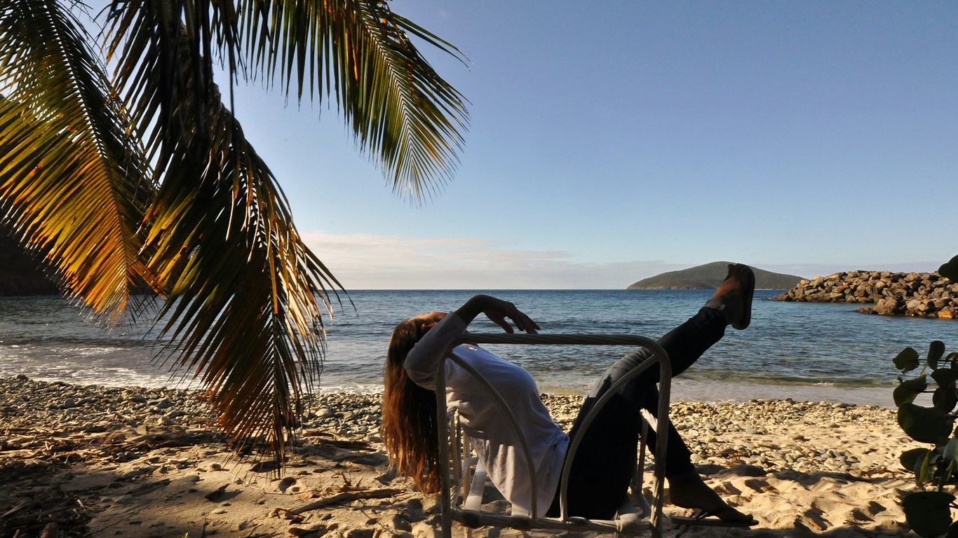 a woman sitting in a chair on the beach