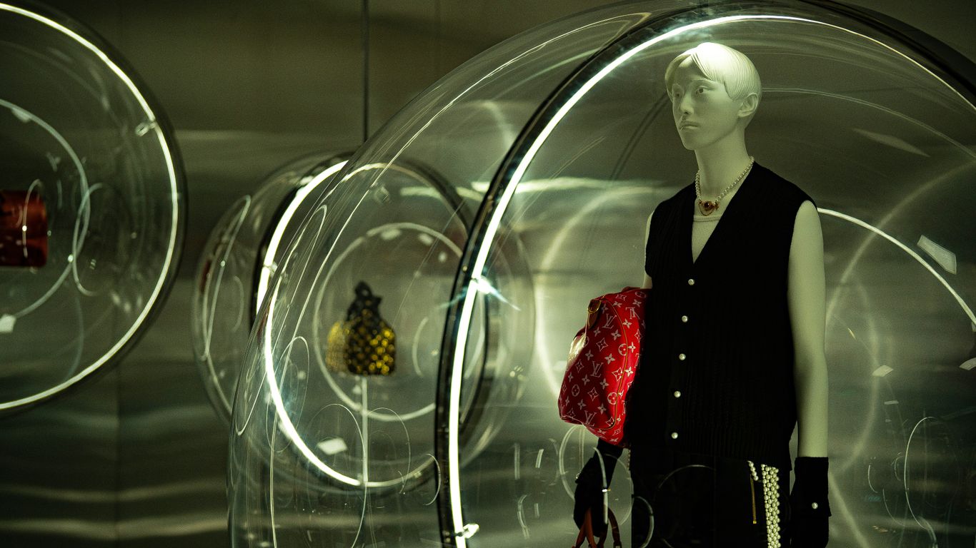 Louis vuitton display with mannequin and handbags.