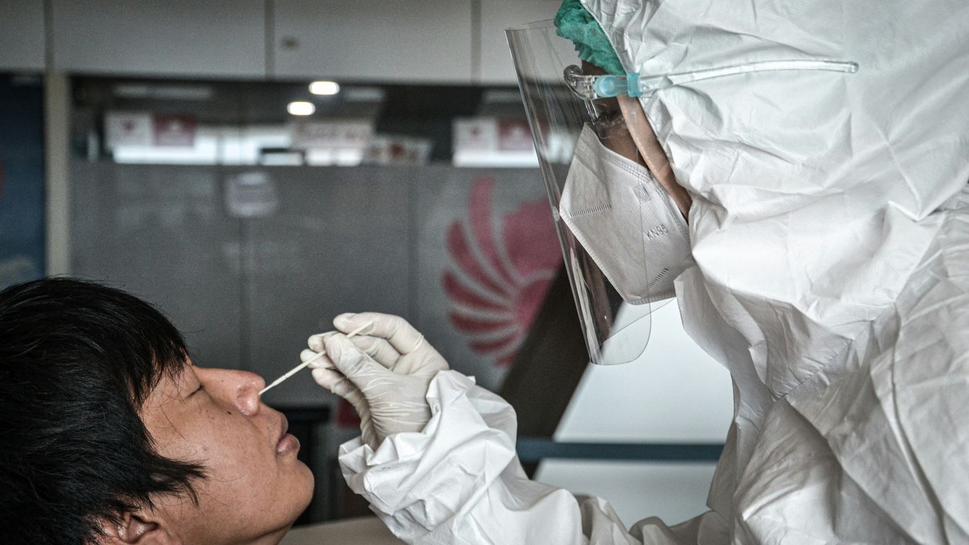 a man in a white suit is putting something in his mouth