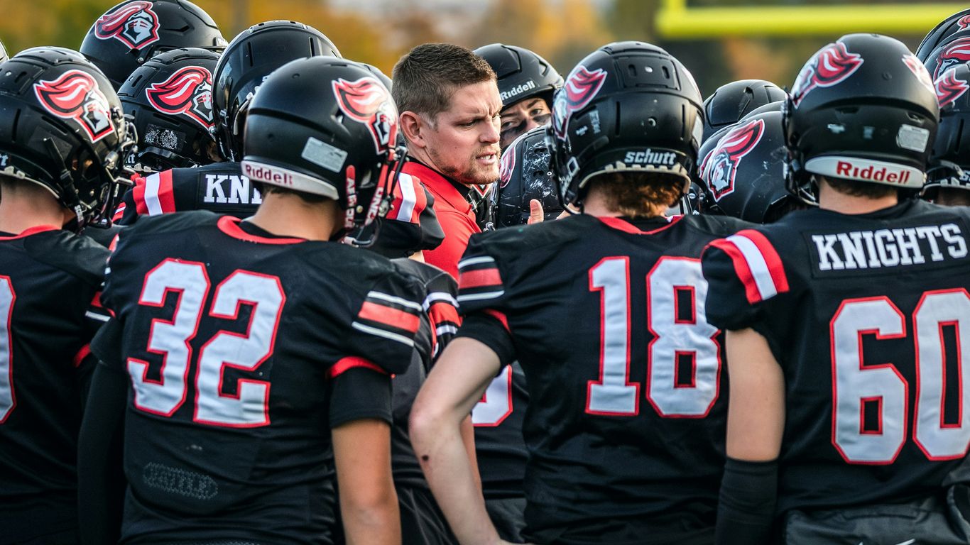 Football coach talking to players in huddle