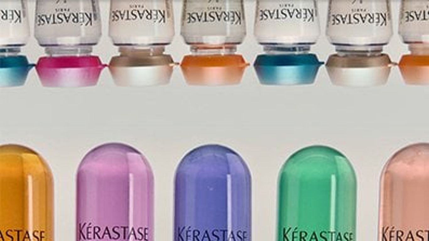 Variety of colorful, branded haircare product bottles in a row.