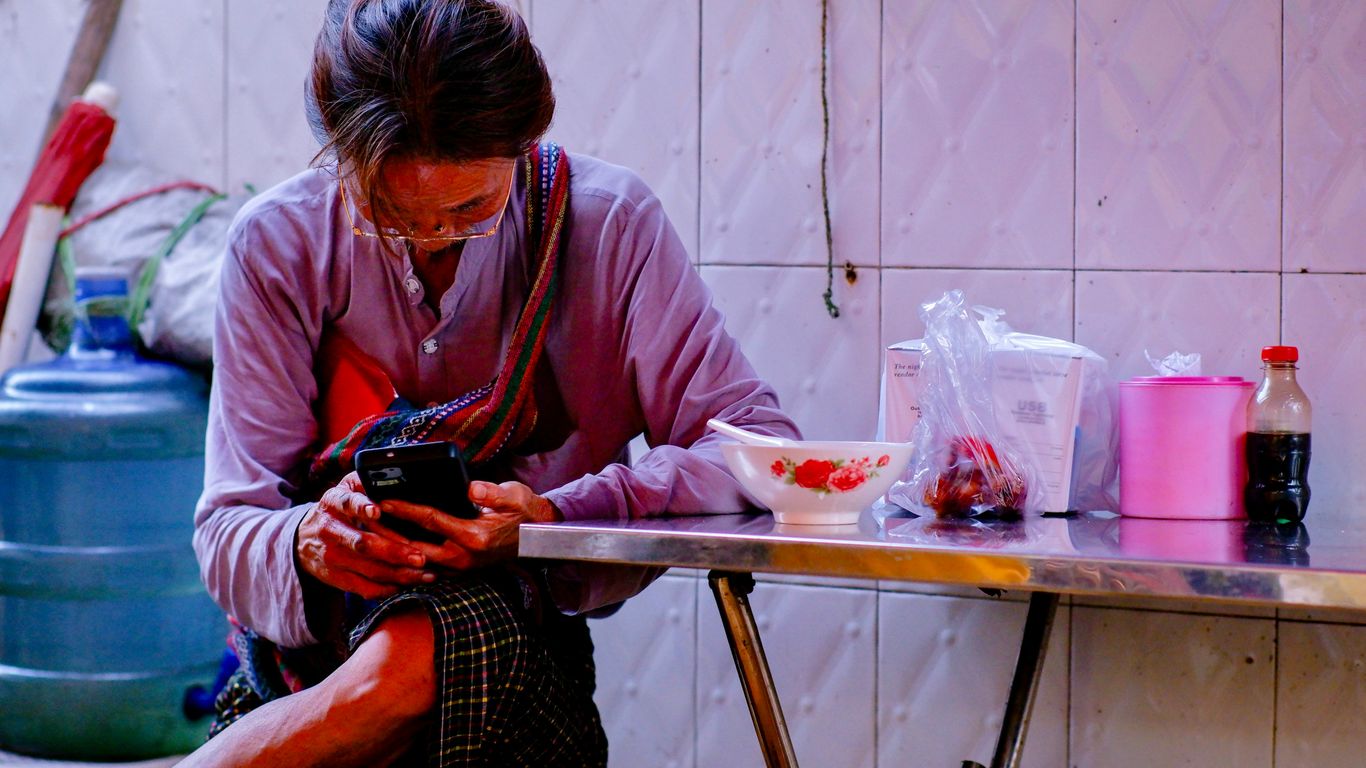 A woman sitting at a table looking at her cell phone