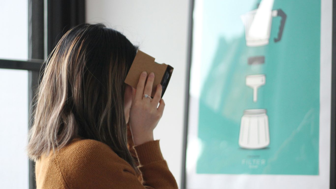 woman wearing sweatshirt near painting with black frame