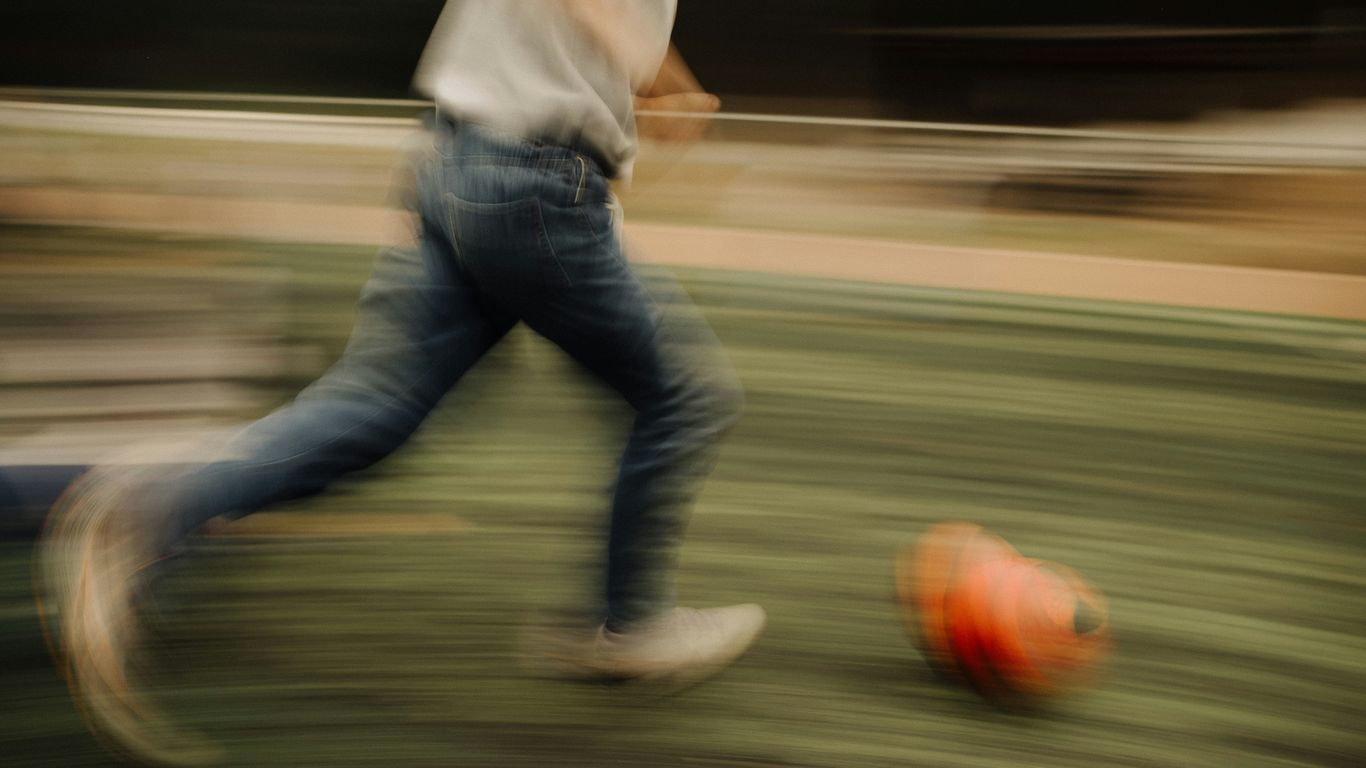 A blurry photo of a man kicking a soccer ball