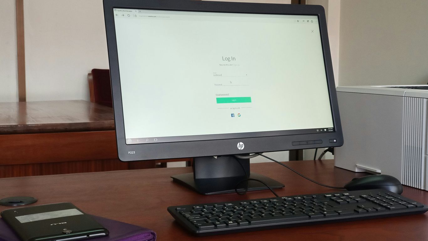 black computer monitor turned on beside black computer keyboard