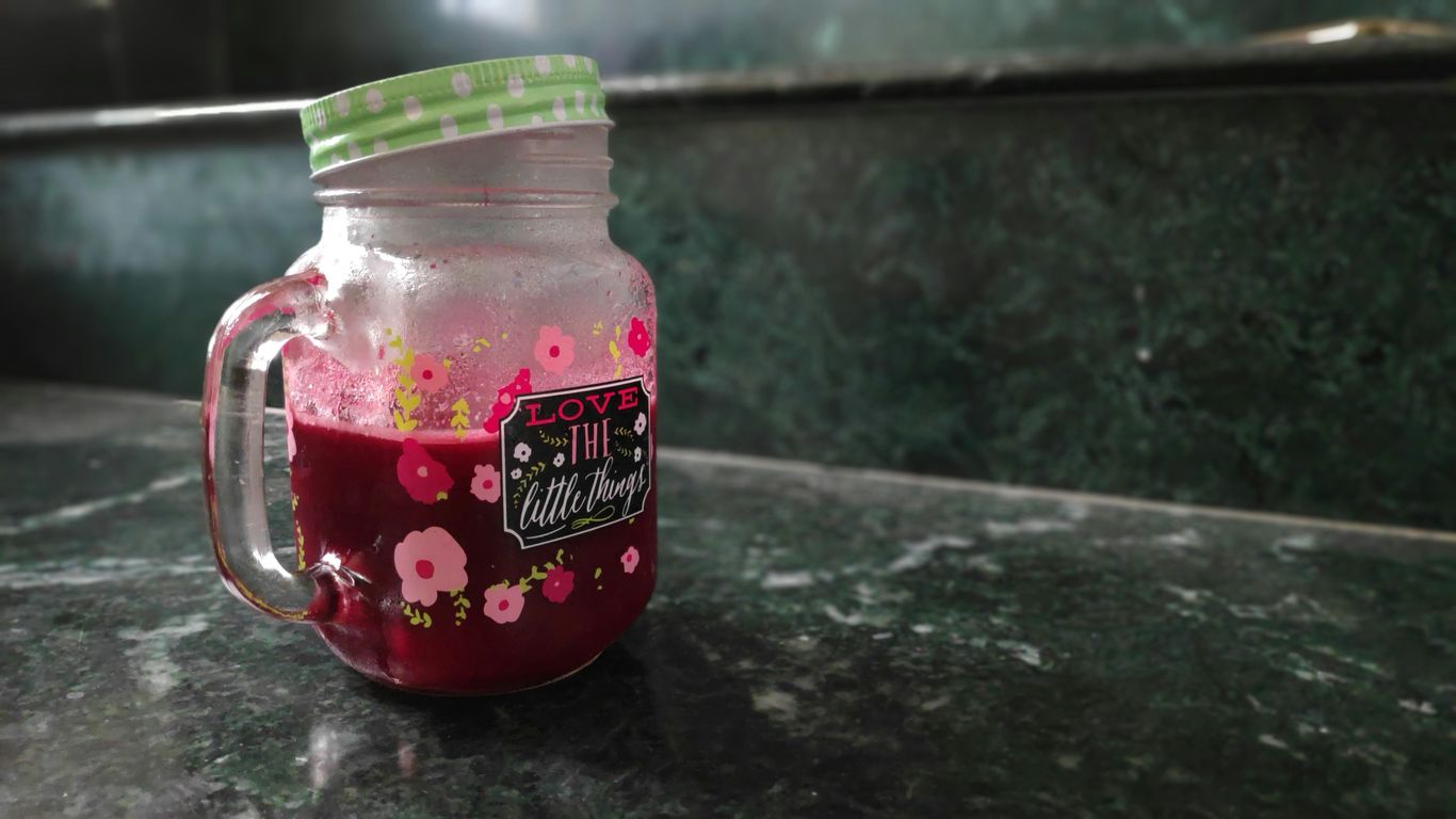 pink liquid inside clear glass jar with lid