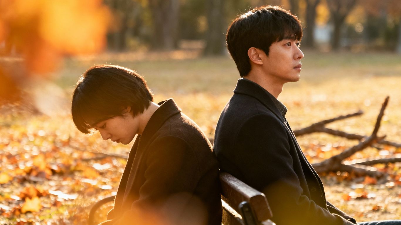 Couple sitting back-to-back, one sad, one looking forward.