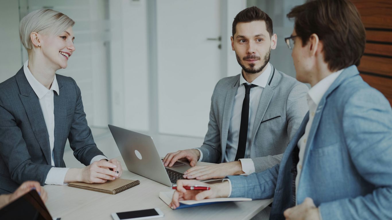 Business professionals in a meeting around a table.