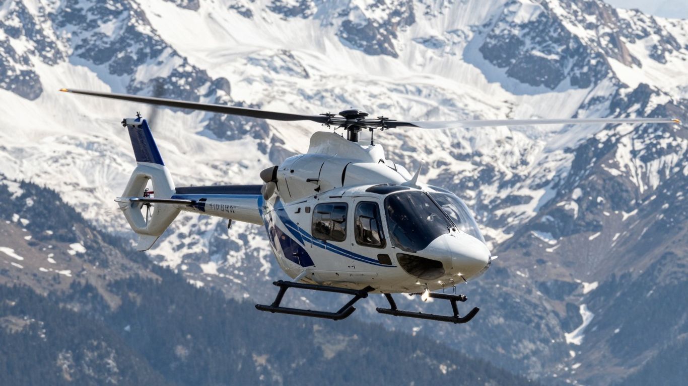 Airbus H145 helicopter flying over snowy Alps.