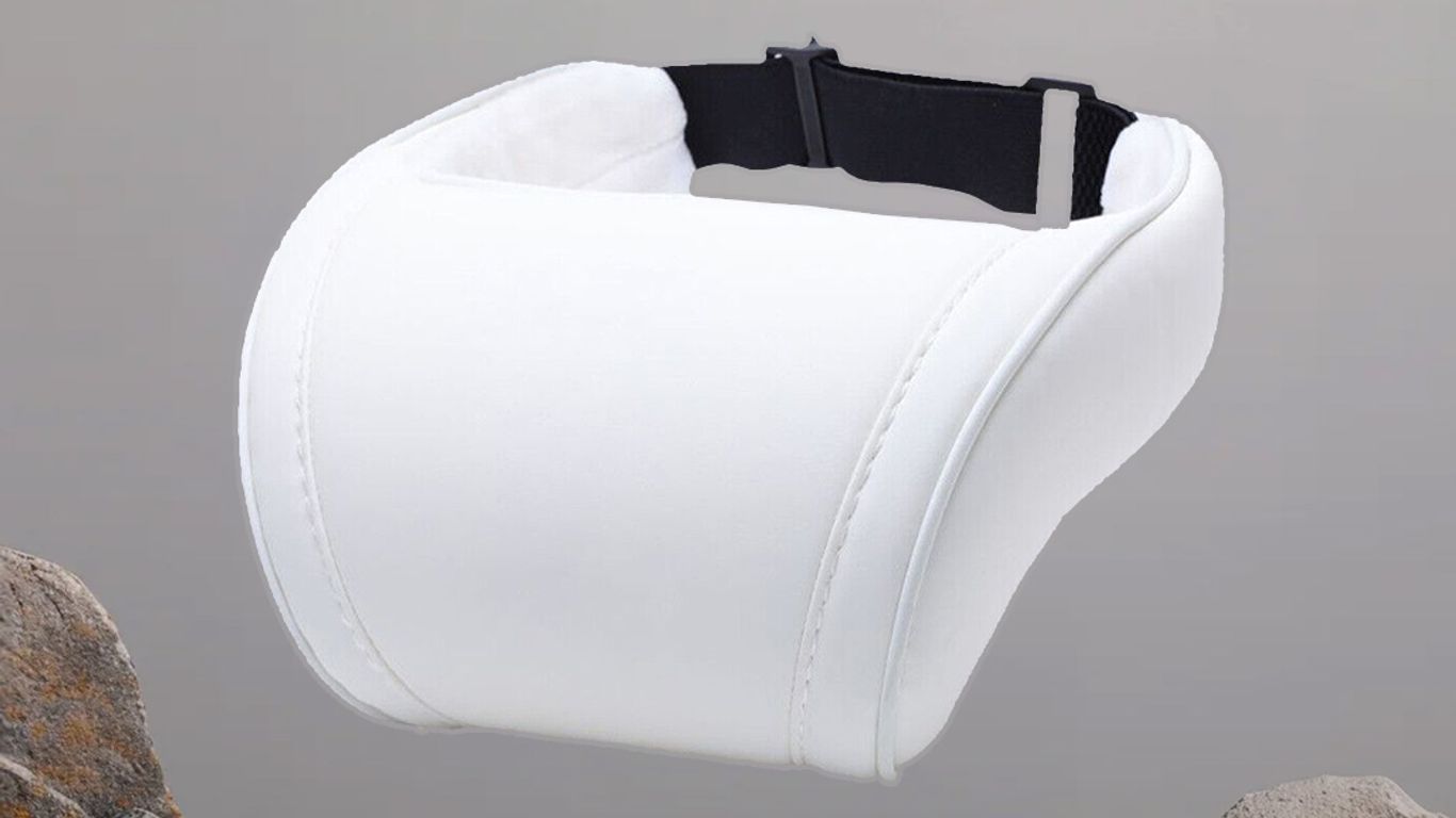 White neck pillow displayed against a neutral background with stones.