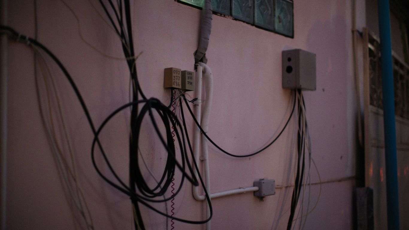 a bunch of wires hanging on the side of a building