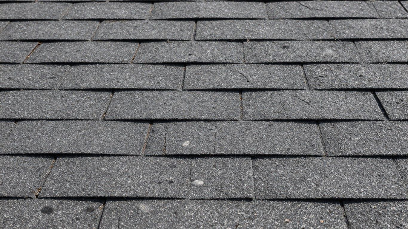 Cracked asphalt shingle on a residential roof.