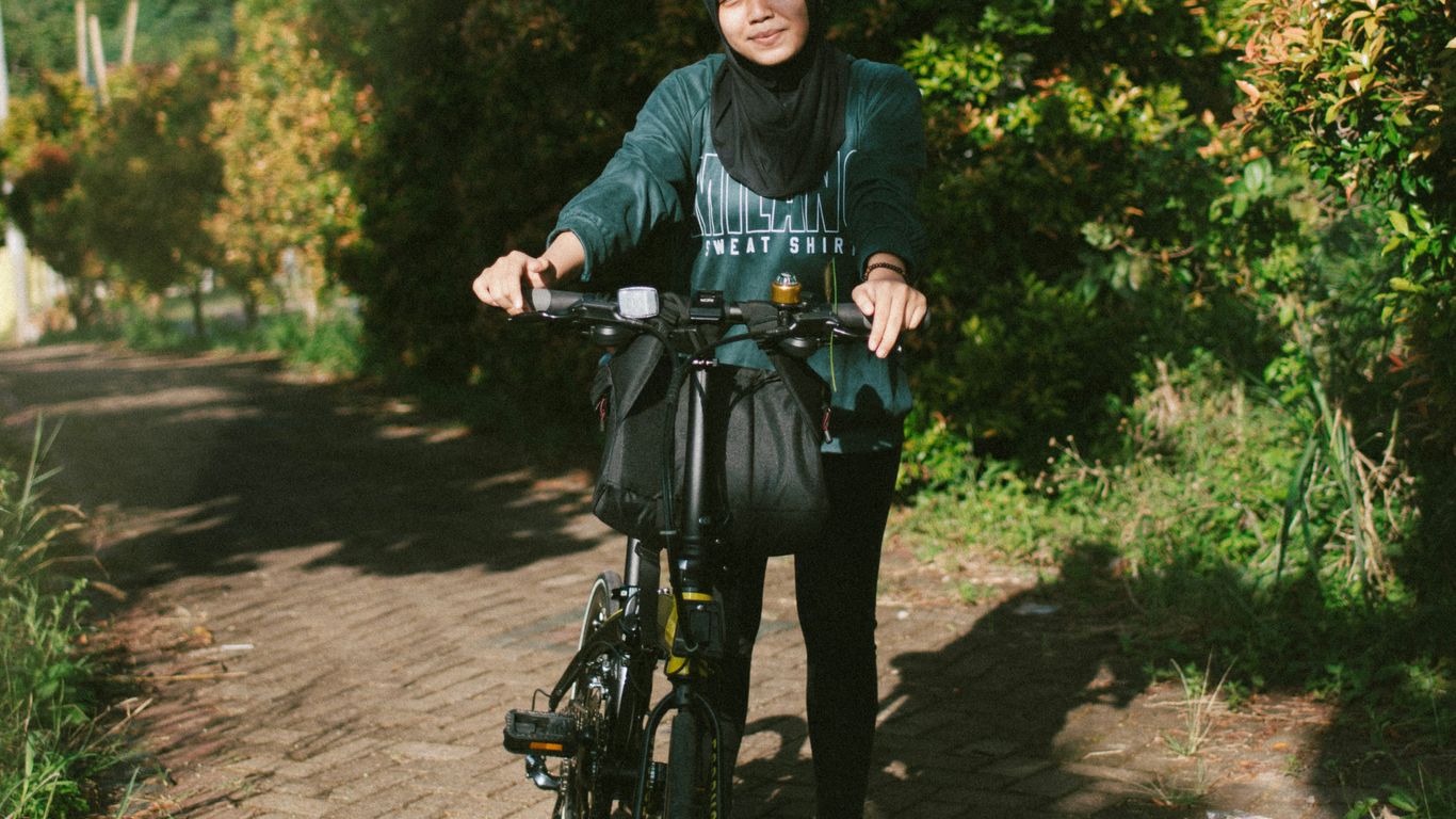 man in black and gray hoodie riding on bicycle